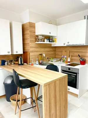 a kitchen with white cabinets and a wooden counter top at Felicity Super Central Apartment in Burgas City