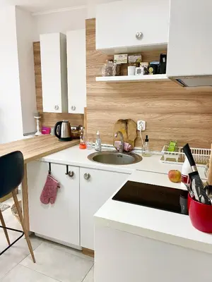 a white kitchen with a sink and a counter at Felicity Super Central Apartment in Burgas City