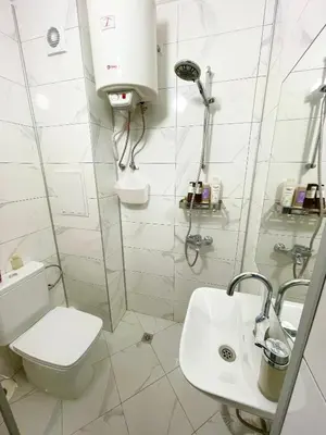 a white bathroom with a toilet and a sink at Felicity Super Central Apartment in Burgas City
