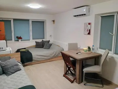 a living room with a bed and a table at Болярска10 in Burgas City