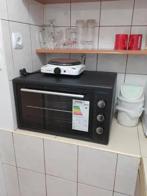 a black microwave sitting on a shelf in a kitchen at Болярска10 in Burgas City
