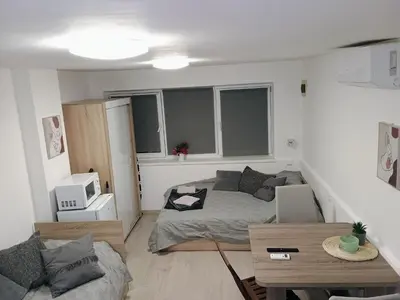 a small living room with a bed and a table at Болярска10 in Burgas City