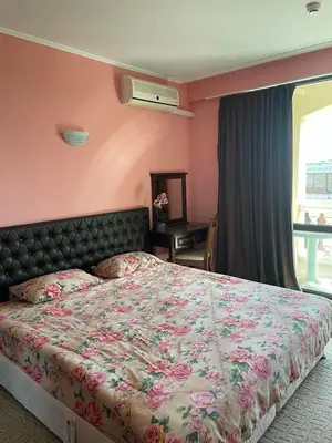 a bedroom with a bed with a floral bedspread at Babylon SP apartment 56 in Sunny Beach