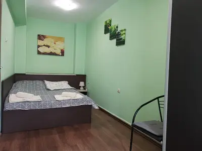 a small bedroom with a bed and a chair at Двустаен апартамент в центъра на гр. Бургас in Burgas City