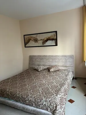 a bedroom with a bed and a picture on the wall at Студио Бургас 2 in Burgas City