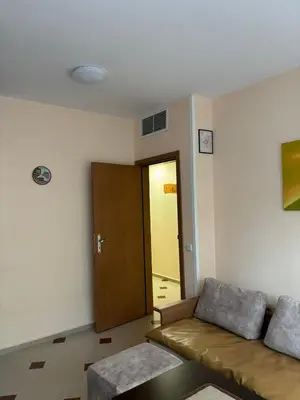 a living room with a couch and a door at Студио Бургас 2 in Burgas City