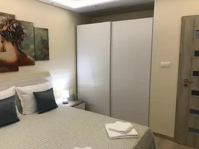 a bedroom with a bed and a wardrobe with towels on it at Sunrise Beach A4, Sarafovo in Burgas City