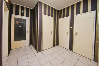 a hallway with three doors and a tile floor at Perla 2-bdrm in the heart of the city in Varna City