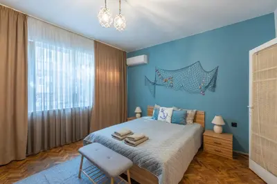 a blue bedroom with a bed and a chair at SeaBed Haven in Varna City