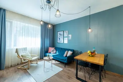 a living room with a blue couch and a table at SeaBed Haven in Varna City