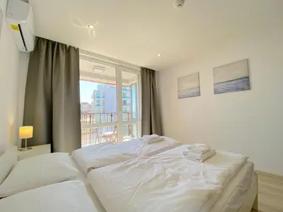 a white bed in a room with a window at Paradiso Aparthotel - Private apartment -BSR-2 in Nesebar
