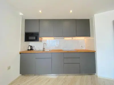 a kitchen with gray cabinets and a sink at Paradiso Aparthotel - Private apartment -BSR-2 in Nesebar