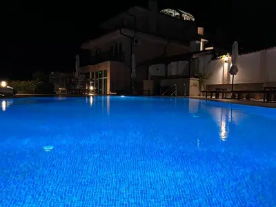 a large blue swimming pool at night at Villa Mia in Sozopol