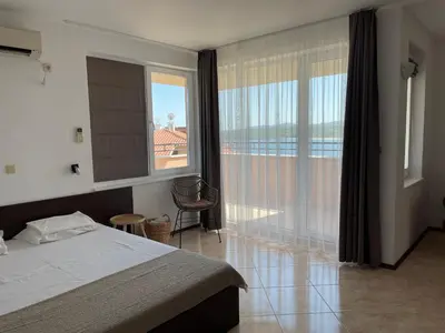 a bedroom with a bed and a view of the ocean at Villa Mia in Sozopol