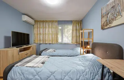 a bedroom with two beds and a tv and a table at Top Center, Sea Garden, Brand New Studio - Majestic in Burgas City