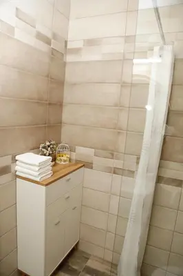 a bathroom with a shower curtain and a white cabinet at Casa Maiolica in Atlantis Atmosphere in Burgas City