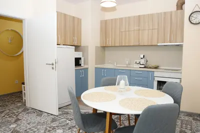 a kitchen with a table and chairs and a white refrigerator at Casa Maiolica in Atlantis Atmosphere in Burgas City