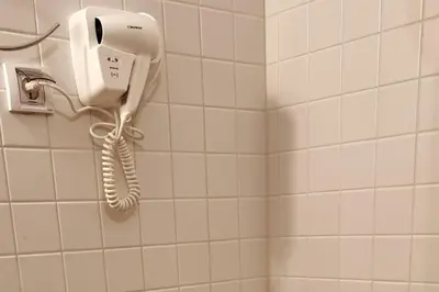 a white phone hanging on a wall in a bathroom at Уютен апартамент близо до морето IGROEG in Burgas City