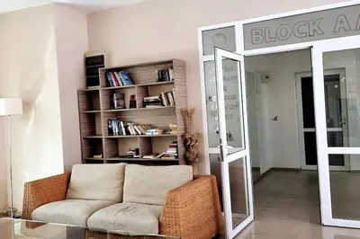 a living room with a couch and a book shelf at Уютен апартамент близо до морето IGROEG in Burgas City