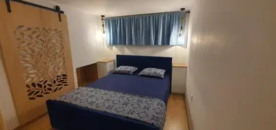 a small room with a blue bed and a window at Brand studio in Varna City