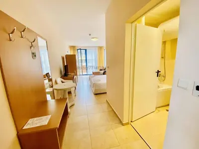 a hotel room with a bedroom and a living room at Trakia Plaza Apartment in Sunny Beach