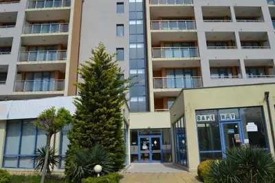 an apartment building with a tree in front of it at Trakia Plaza Apartment in Sunny Beach