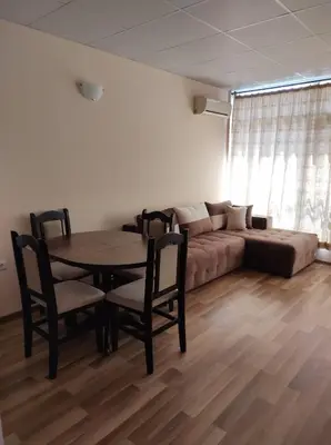 a living room with a table and chairs and a couch at Dunav-Lazur Apt.5 in Ravda