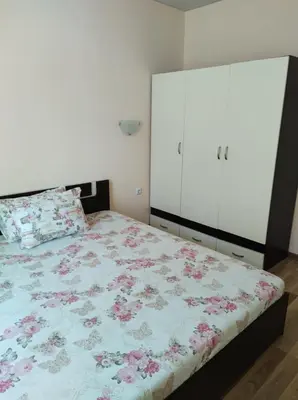 a bedroom with a bed with a floral bedspread at Dunav-Lazur Apt.5 in Ravda