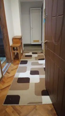 a hallway with a checkered floor next to a door at 27 юли 3 бюджет in Varna City