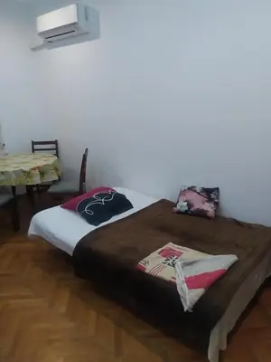 a large bed in a room with a table at 27 юли 3 бюджет in Varna City