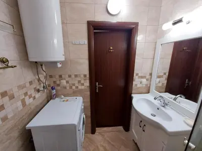 a bathroom with a sink and a toilet and a mirror at Студио Прованс Лариса in Pomorie