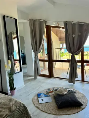 a room with a bed with a laptop on the floor at Sunrise place Eva in Sozopol