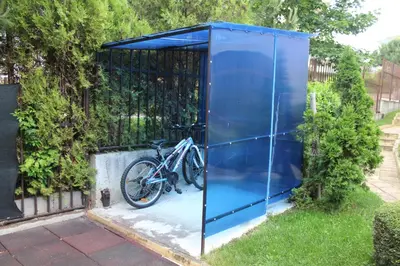 a bicycle is parked inside of a blue garage at Apart complex Starfish със собствено паркомясто in Sveti Vlas