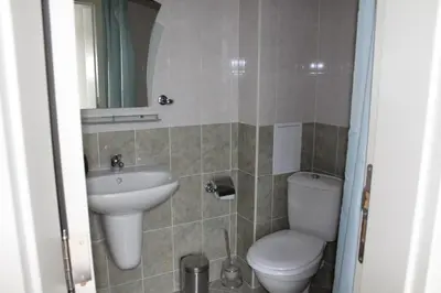 a bathroom with a toilet and a sink at Apart complex Starfish със собствено паркомясто in Sveti Vlas
