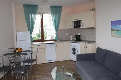 a kitchen and a living room with a couch and a table at Apart complex Starfish със собствено паркомясто in Sveti Vlas