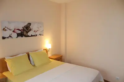 a bedroom with a white bed with two yellow pillows at Apart complex Starfish със собствено паркомясто in Sveti Vlas