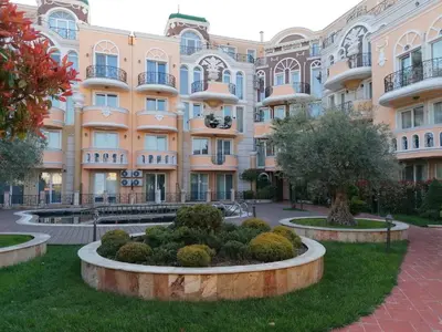 a large building with a garden in front of it at Marina Studio in Ravda