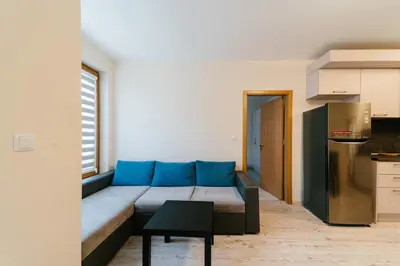 a living room with a blue couch in a kitchen at Апартамент за гости Веси in Burgas City
