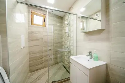 a bathroom with a shower and a sink at Апартамент за гости Веси in Burgas City