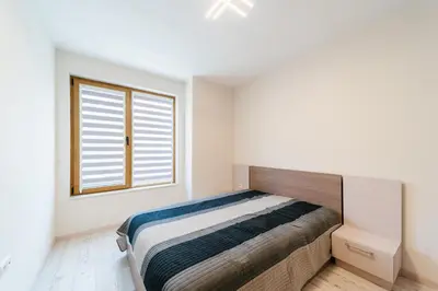 a bedroom with a bed and a window at Апартамент за гости Веси in Burgas City
