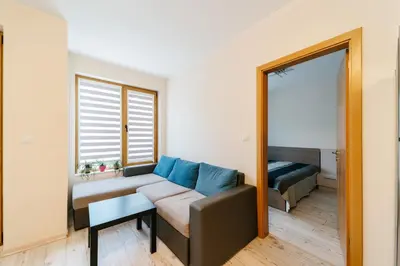 a living room with a couch and a mirror at Апартамент за гости Веси in Burgas City