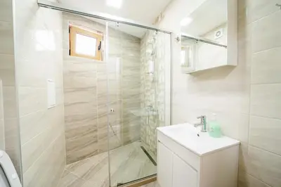 a bathroom with a shower and a sink at Апартамент за гости Веси in Burgas City