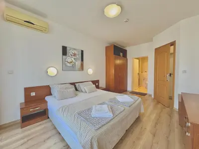 a bedroom with a bed and a wooden floor at Two bedroom apartment in Trakia Sunny Beach in Sunny Beach