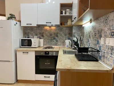a kitchen with white cabinets and a sink and a refrigerator at Two bedroom apartment in Trakia Sunny Beach in Sunny Beach