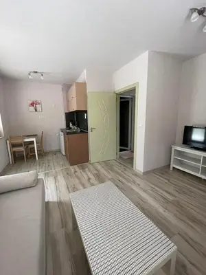 an empty living room with a couch and a kitchen at Къща за гости “Недев” in Tsarevo