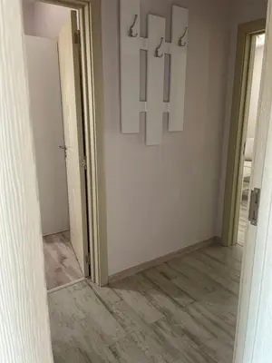 a hallway with a white wall with a cross on it at Къща за гости “Недев” in Tsarevo
