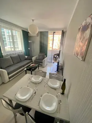 a white dining room table with wine glasses on it at Apartman Kuba in Primorsko