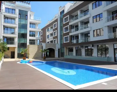 a swimming pool in front of a apartment building at Apartman Kuba in Primorsko