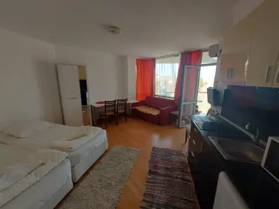 a living room with a white couch and a television at Studios & Apartments Perla in Sunny Beach