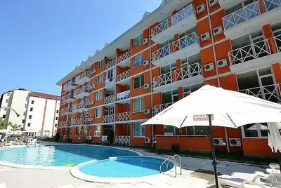 a large building with a swimming pool and an umbrella at Gerber Residence 2 in Sunny Beach